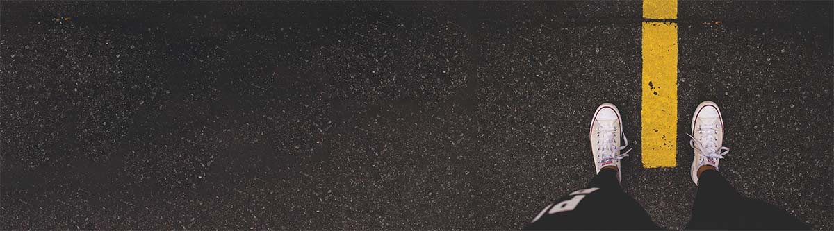 shoes standing on yellow line in road